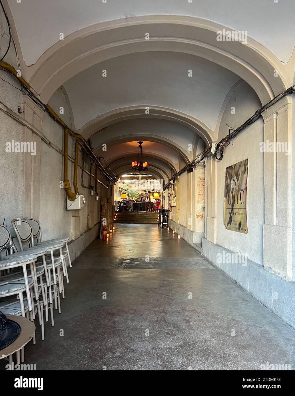Passaggio ad arco bianco e giallo nell'edificio storico che conduce al ristorante. Fotografia di strada. Cluj-Napoca, Romania Foto Stock