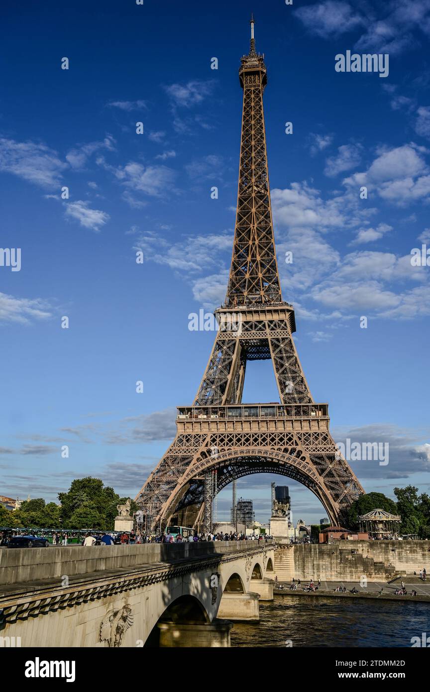 Parigi, Francia, 1 luglio 2022. La Torre Eiffel vista dalla riva opposta della Senna. La calda luce del tardo pomeriggio lo illumina completamente. Blu sk Foto Stock