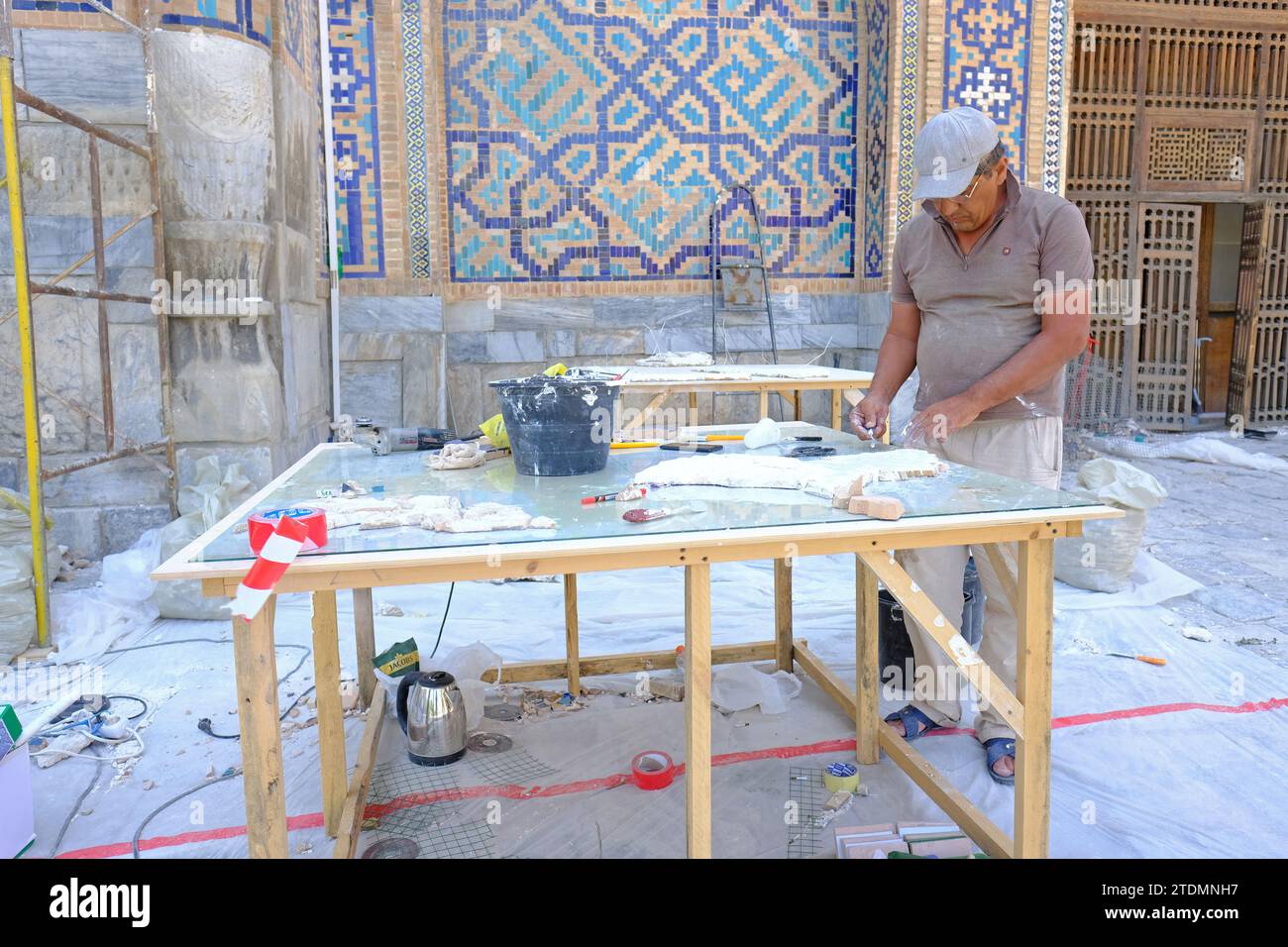 Lavoratori dell'Uzbekistan di Samarcanda che si preparano a rinnovare parti dei motivi decorati di piastrelle blu presso il Registan nell'agosto 2022 Foto Stock
