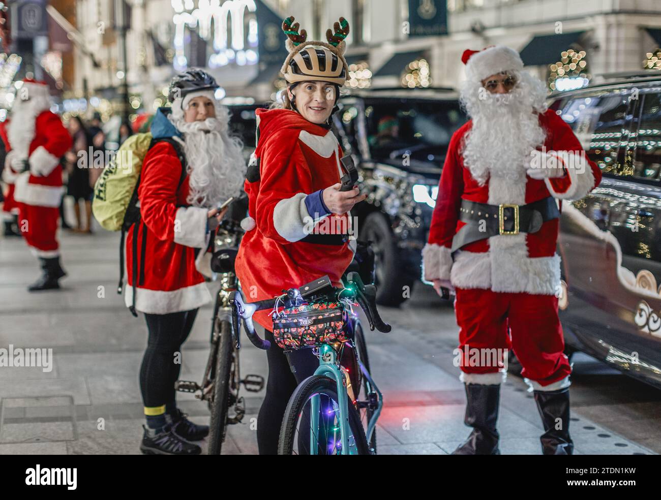 In bicicletta incontrerai altri santas a Mayfair di Londra. Foto Stock