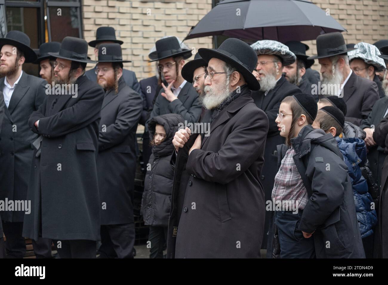 Una folla di ebrei chassidici in lutto ascolta gli elogi al funerale di un amato rabbino. A Brooklyn, New York Foto Stock