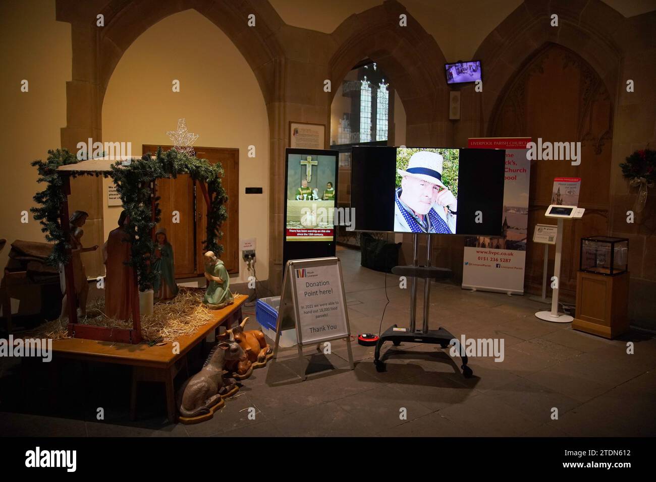 Una foto viene visualizzata su uno schermo davanti al funerale per l'ex attore Dean Sullivan di Brookside presso la chiesa parrocchiale di Liverpool (nostra Signora e San Nicola). Noto per aver interpretato Jimmy Corkhill nella soap opera di Mersey, l'attore e regista Liverpudlian morì all'età di 68 anni a seguito di una "breve malattia". Data immagine: Martedì 19 dicembre 2023. Foto Stock