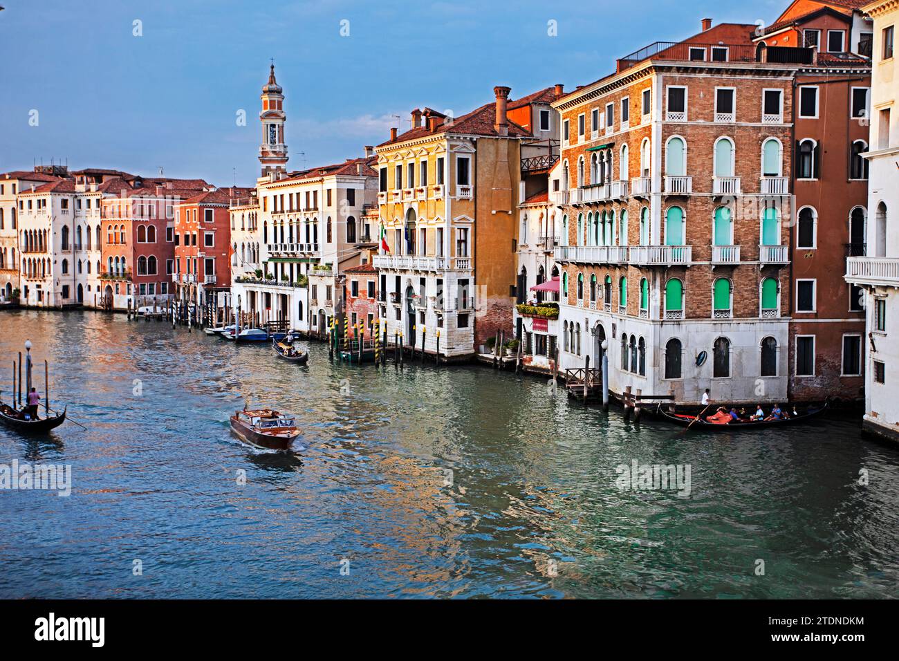 Splendidi edifici stratificati lungo il canale veneziano con gondole e trasporto pubblico su acqua a Venezia. Viaggi e turismo Foto Stock