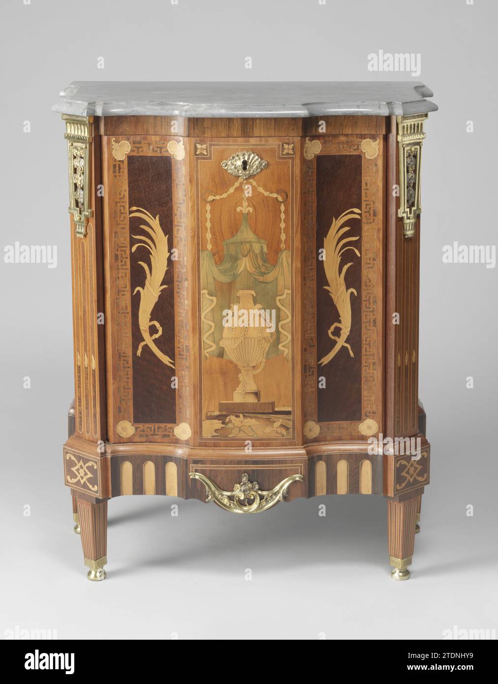 Commode e due armadi, anonimi, c. 1770 - c. 1790 armadio Estate, incollato con legni diversi e dotato di pastella di rame dorato e foglia di marmo grigio-bianco-venato. Lo scafo si trova su un telaio allentato con gambe quadrate che poggiano su piedini metallici. Il pannello centrale sulla porta ha una cordicella di marquetera di un vaso con rami di palma legati tra loro su entrambi i lati. Sui lati dell'armadio sono stati applicati dei semplici trofei sospesi di un manicotto a freccia e di una torcia. L'asse nella credenza ha un'oscillazione al centro. Quercia olandese (legno). rosewood (legno). rosewood (legno). cuore viola (legno). l Foto Stock