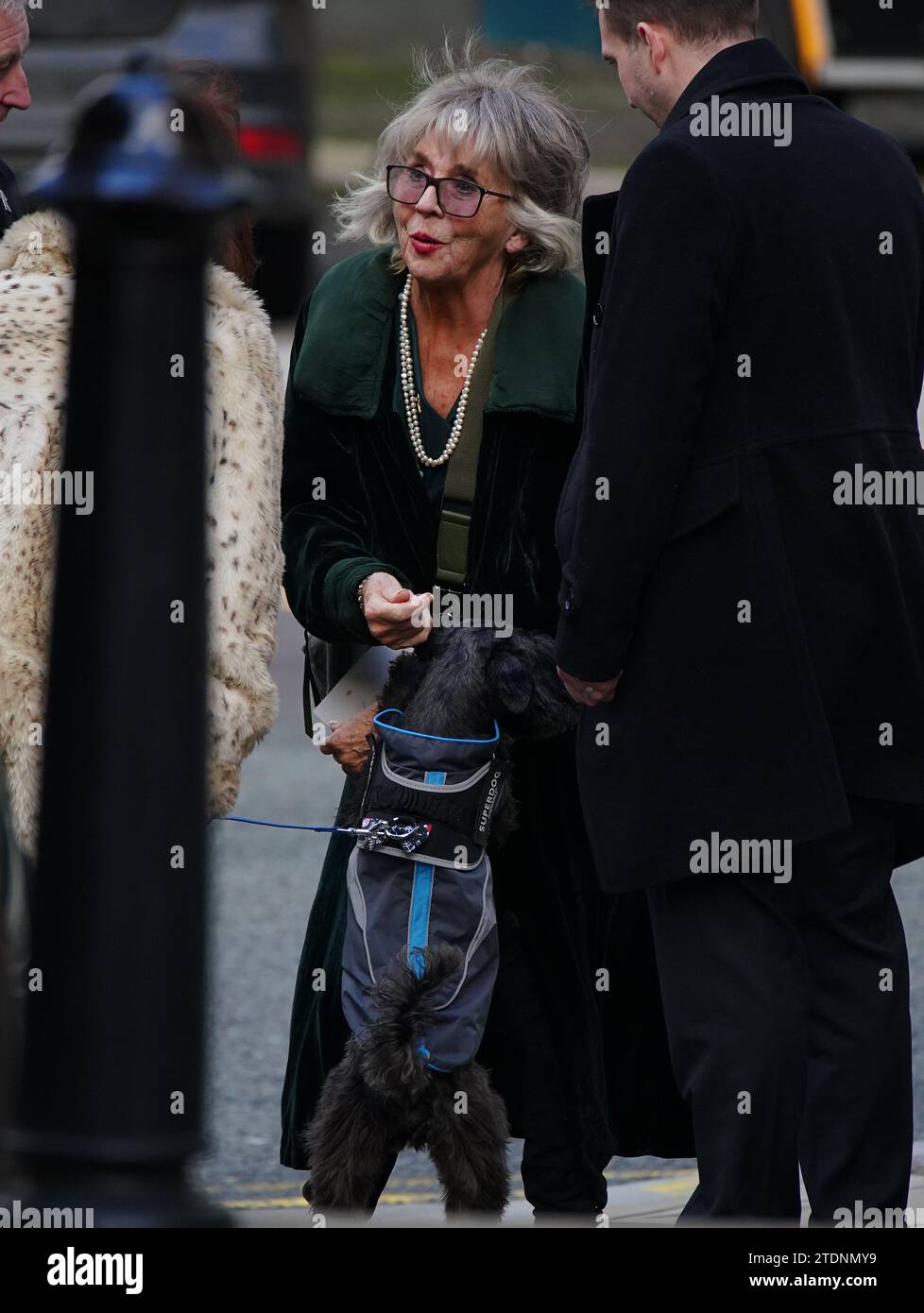 L'attrice sue Johnston accarezza Billy the Schnauzer il cane dell'ex attore Dean Sullivan, mentre arriva per il suo funerale alla chiesa parrocchiale di Liverpool (nostra Signora e San Nicola). Noto per aver interpretato Jimmy Corkhill nella soap opera di Mersey, l'attore e regista Liverpudlian morì all'età di 68 anni a seguito di una "breve malattia". Data immagine: Martedì 19 dicembre 2023. Foto Stock