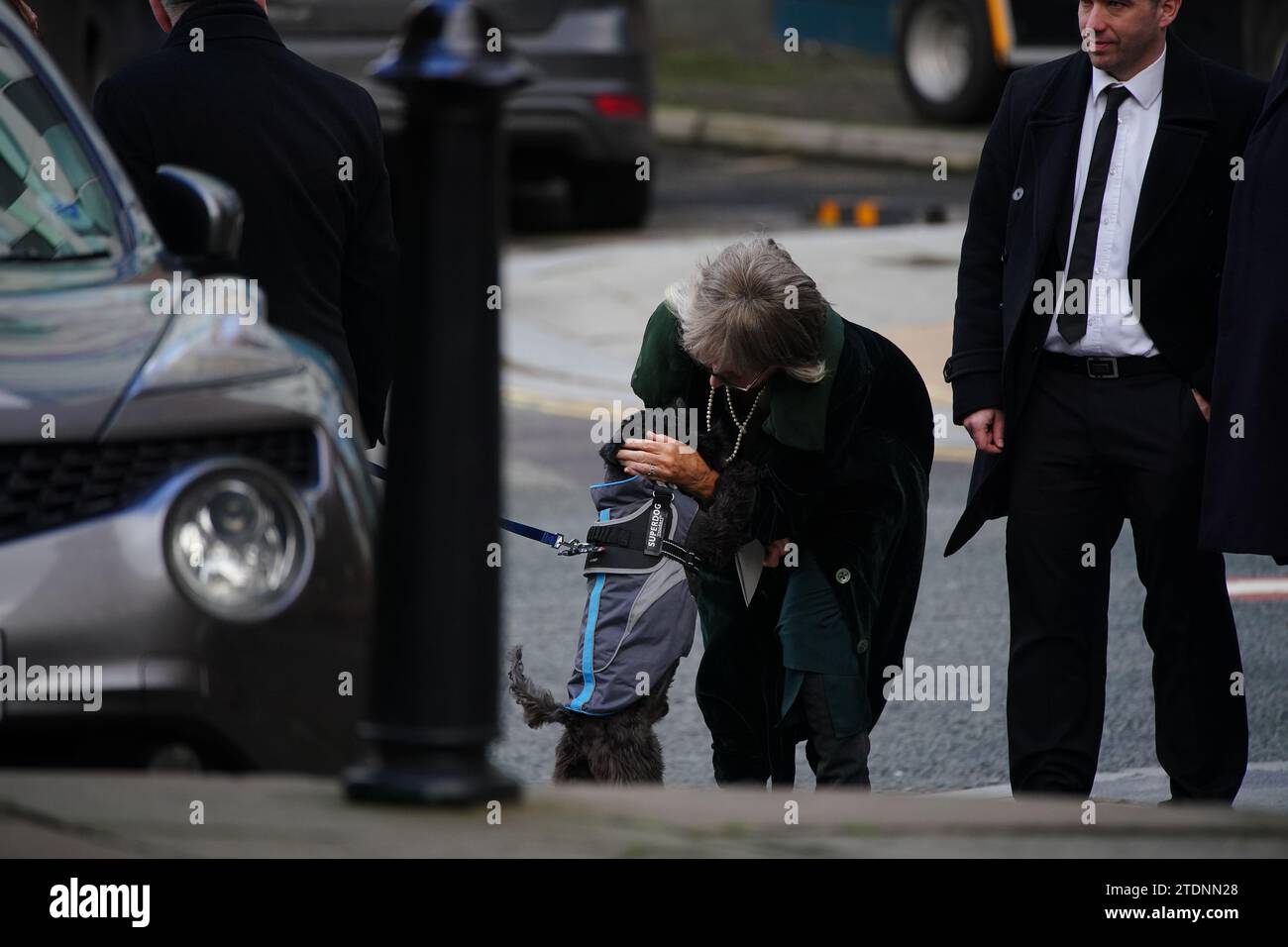 L'attrice sue Johnston accarezza Billy the Schnauzer il cane dell'ex attore Dean Sullivan, mentre arriva per il suo funerale alla chiesa parrocchiale di Liverpool (nostra Signora e San Nicola). Noto per aver interpretato Jimmy Corkhill nella soap opera di Mersey, l'attore e regista Liverpudlian morì all'età di 68 anni a seguito di una "breve malattia". Data immagine: Martedì 19 dicembre 2023. Foto Stock