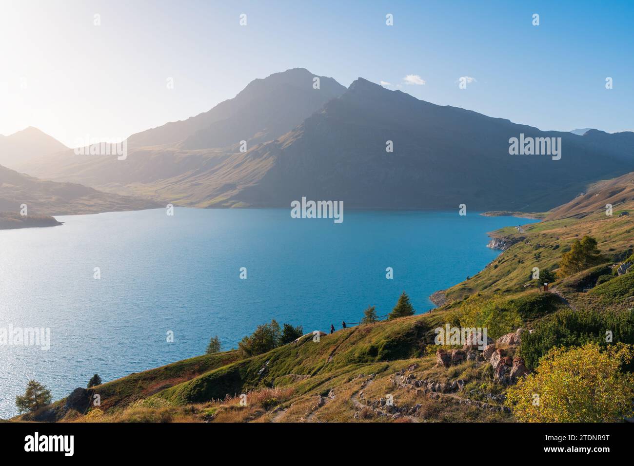 Monte Cenis (Moncenisio), lago e vetta montuosa (Val-Cenis), cielo blu, luce soffusa, riva e acqua limpida Foto Stock