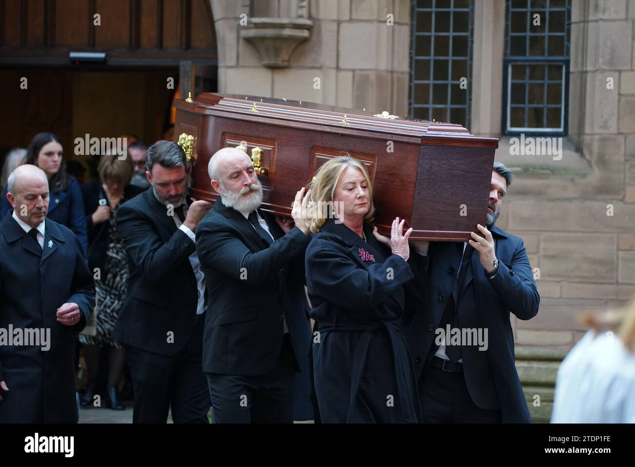 La bara dell'ex attore di Brookside Dean Sullivan è portata dal suo funerale alla Liverpool Parish Church (nostra Signora e San Nicola). Noto per aver interpretato Jimmy Corkhill nella soap opera di Mersey, l'attore e regista Liverpudlian morì all'età di 68 anni a seguito di una "breve malattia". Data immagine: Martedì 19 dicembre 2023. Foto Stock
