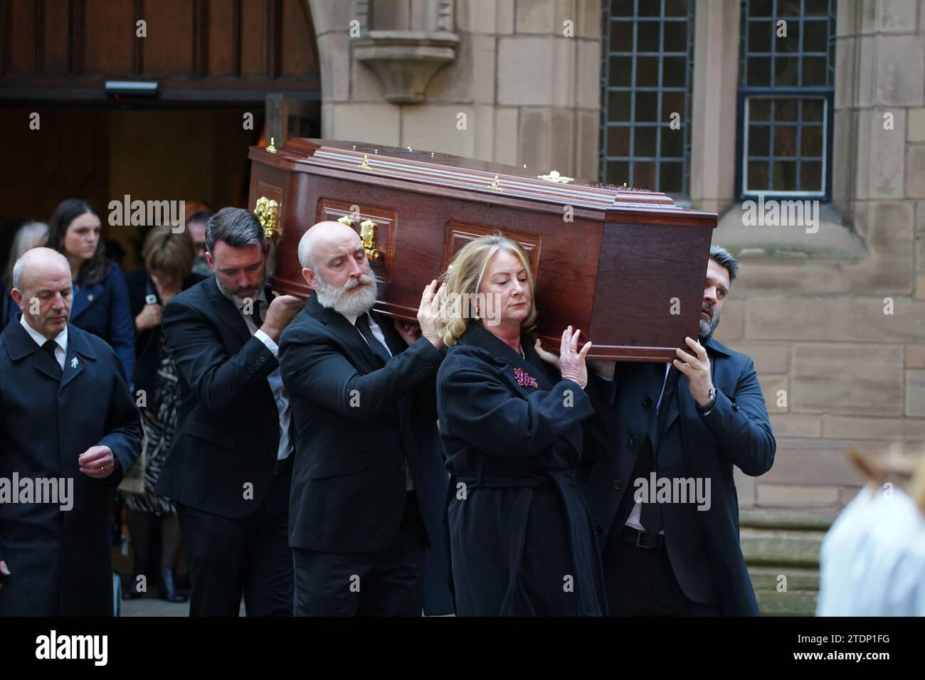 La bara dell'ex attore di Brookside Dean Sullivan è portata dal suo funerale alla Liverpool Parish Church (nostra Signora e San Nicola). Noto per aver interpretato Jimmy Corkhill nella soap opera di Mersey, l'attore e regista Liverpudlian morì all'età di 68 anni a seguito di una "breve malattia". Data immagine: Martedì 19 dicembre 2023. Foto Stock