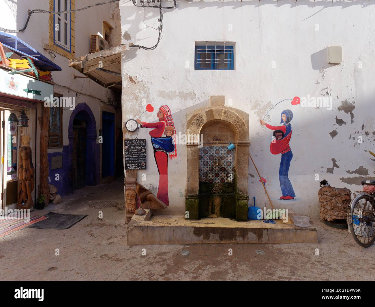 Fontana d'acqua e opere d'arte colorate nella medina della città di Essaouira, Marocco. 19 dicembre 2023 Foto Stock