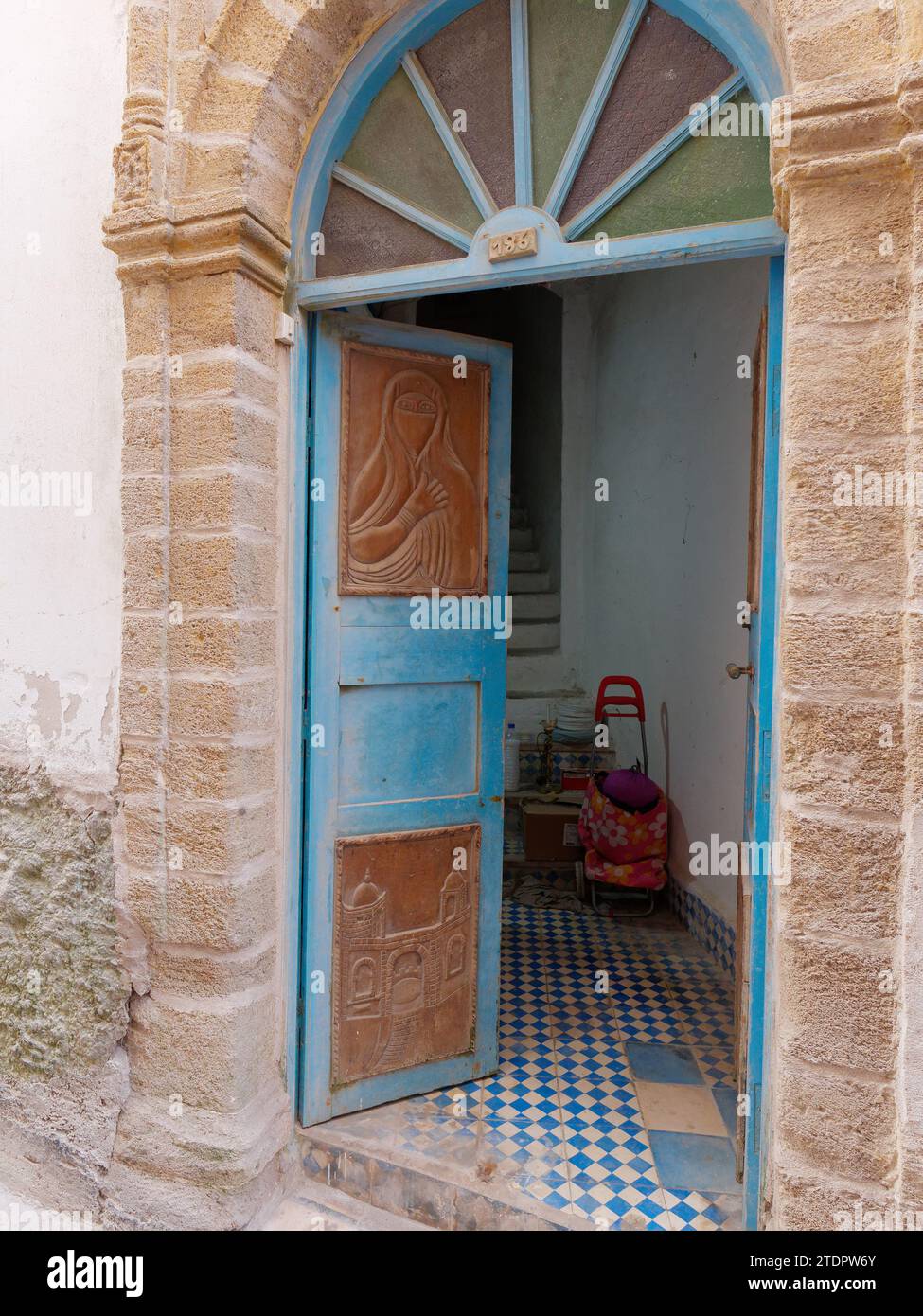 Porta ad arco e pannellate in legno con design e interni piastrellati nella medina nella città di Essaouira, Marocco. 19 dicembre 2023 Foto Stock