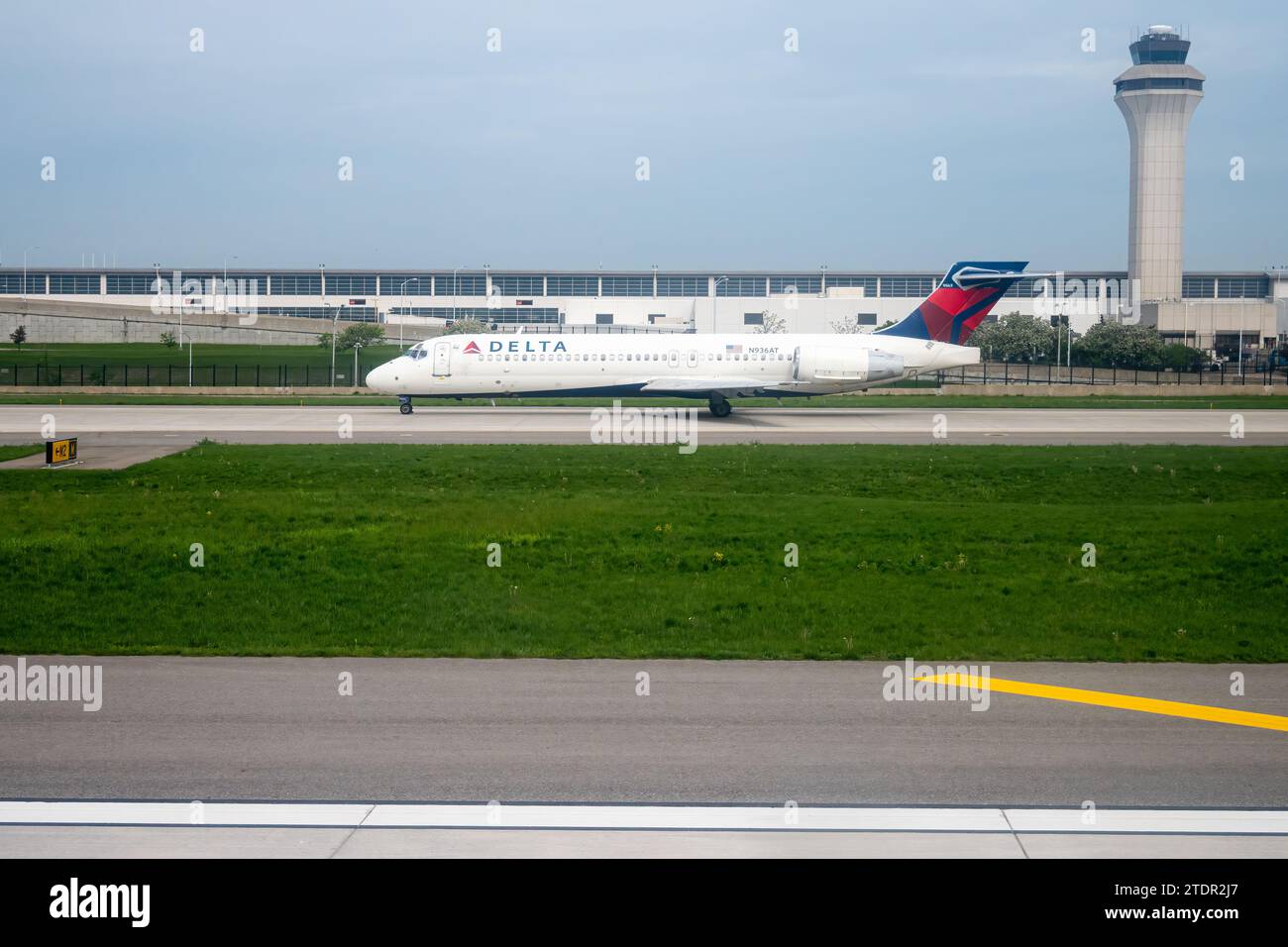 Un taxi aereo Delta Airlines Boeing 717-231 passeggeri di fronte alla torre presso l'aeroporto metropolitano di Detroit (DTW) vicino a Detroit, Michigan, Stati Uniti. Foto Stock
