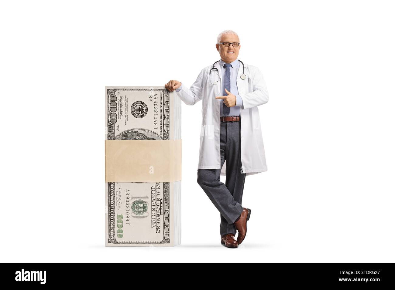 Medico maschio appoggiato su una pila di soldi e puntato isolato su sfondo bianco Foto Stock