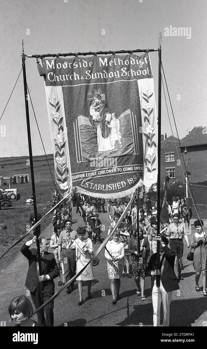 Anni '1960, storico, passeggiata parrocchiale, gente in processione con alcuni che reggono uno striscione religioso della Chiesa Metodista e della Scuola domenicale di Moorside, con il messaggio. "Soffri bambini, vieni da me". La chiesa fu fondata nel 1884. Foto Stock