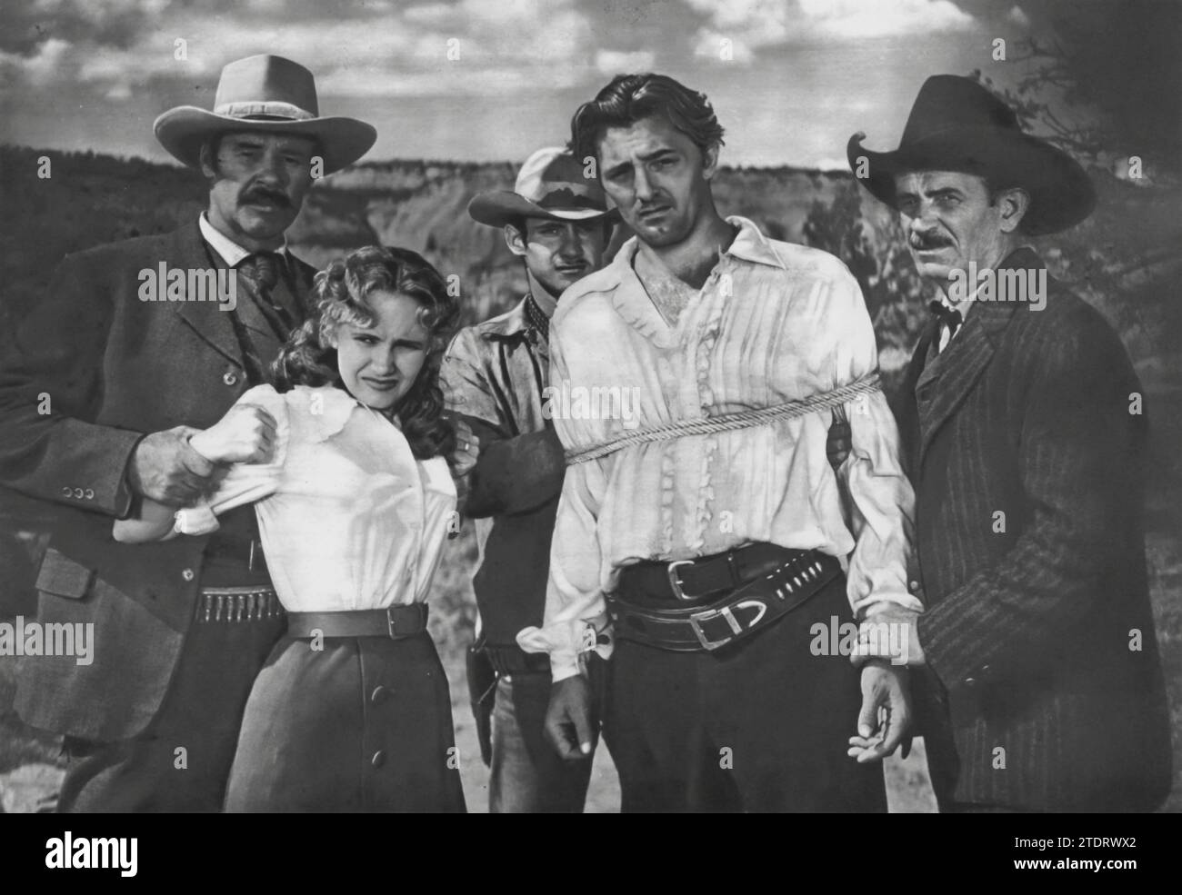 Robert Mitchum e Teresa Wright sono i protagonisti di The Western 'Pursuit' (1947). Questo film, diretto da Raoul Walsh, fonde elementi del genere occidentale con aspetti thriller psicologici. Mitchum interpreta Jeb Rand, un uomo infestato dal suo passato traumatico, mentre Wright interpreta il suo interesse amoroso, Thorley. La narrazione intreccia una complessa storia di faide familiari, vendetta e segreti oscuri, ambientata sullo sfondo del paesaggio del New Mexico. 'Pursuit' è notevole per la sua atmosfera lunatica e le intense performance di Mitchum e Wright, che lo rendono un'entrata unica e avvincente nel genere occidentale. Foto Stock