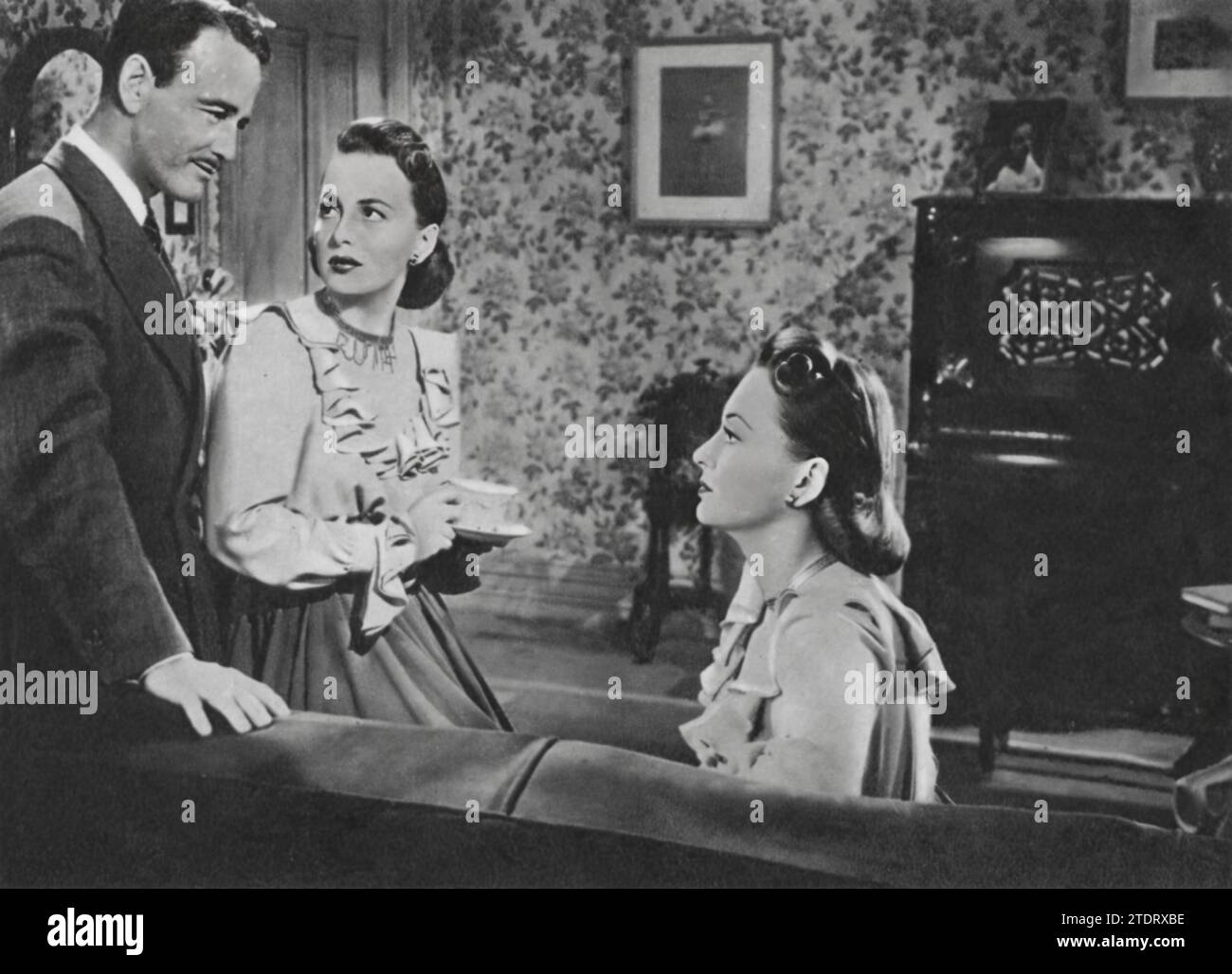 Olivia de Havilland interpreta un duplice ruolo impegnativo in "The Dark Mirror" (1946), insieme a Lew Ayres. In questo thriller psicologico, de Havilland ritrae sorelle gemelle, una delle quali è sospettata di omicidio. Ayres interpreta lo psichiatra che viene coinvolto nello svelare il mistero. Il film approfondisce i temi dell'identità e della complessità psicologica, con la performance di de Havilland che sottolinea la sua versatilità come attrice. Foto Stock