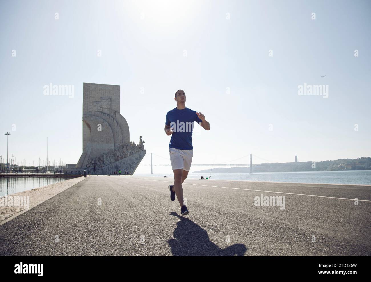Uomo che corre accanto a Padrão dos Descobrimentos a Lisbona, Portogallo Foto Stock