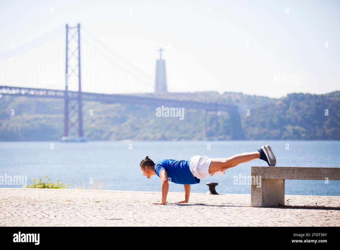 Uomo che si esercita con pushup a Lisbona, vicino al fiume Foto Stock