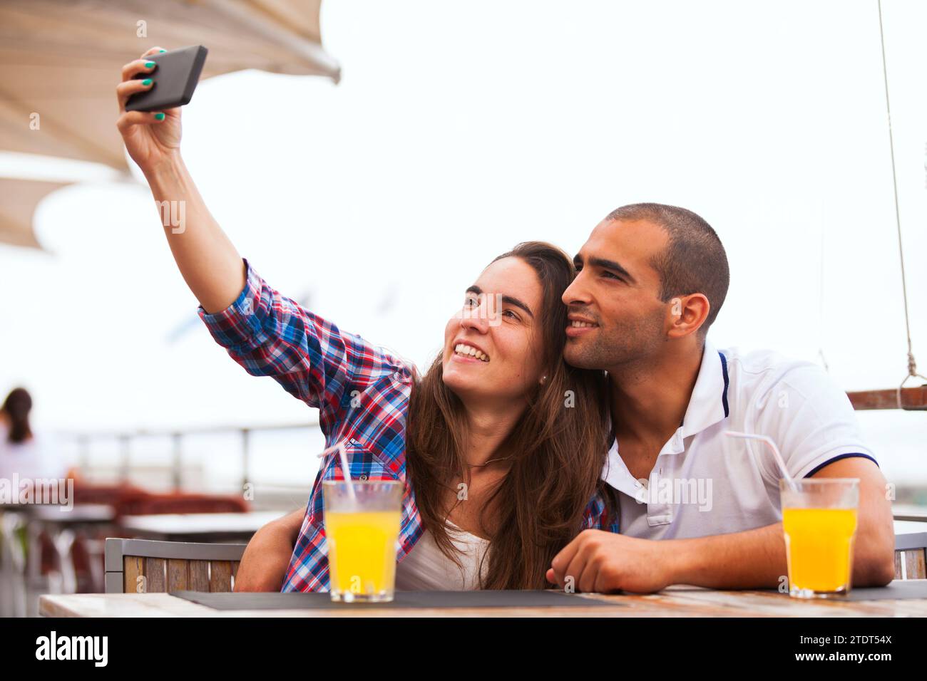 Coppia felice al bar che fa selfie Foto Stock