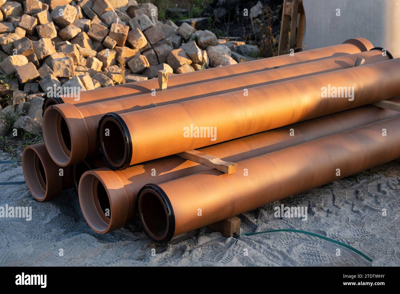 Cumulo di tubi di drenaggio delle fognature in ceramica sul cantiere. Digged New Infrastructure, supply Systems Foto Stock