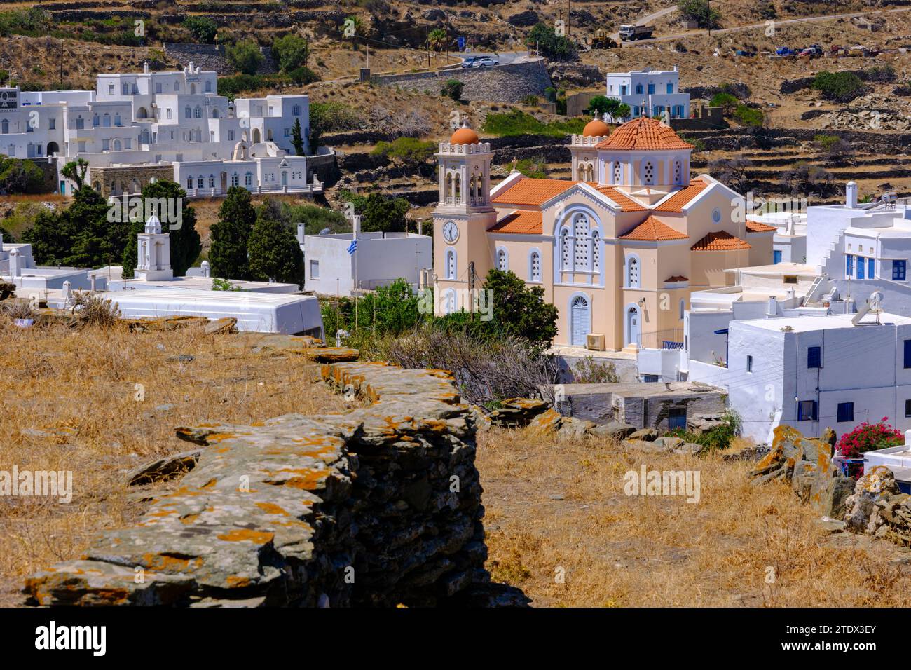 Pyrgos, GR - 6 agosto 2023: Chiesa, case bianche e paesaggio arido Foto Stock