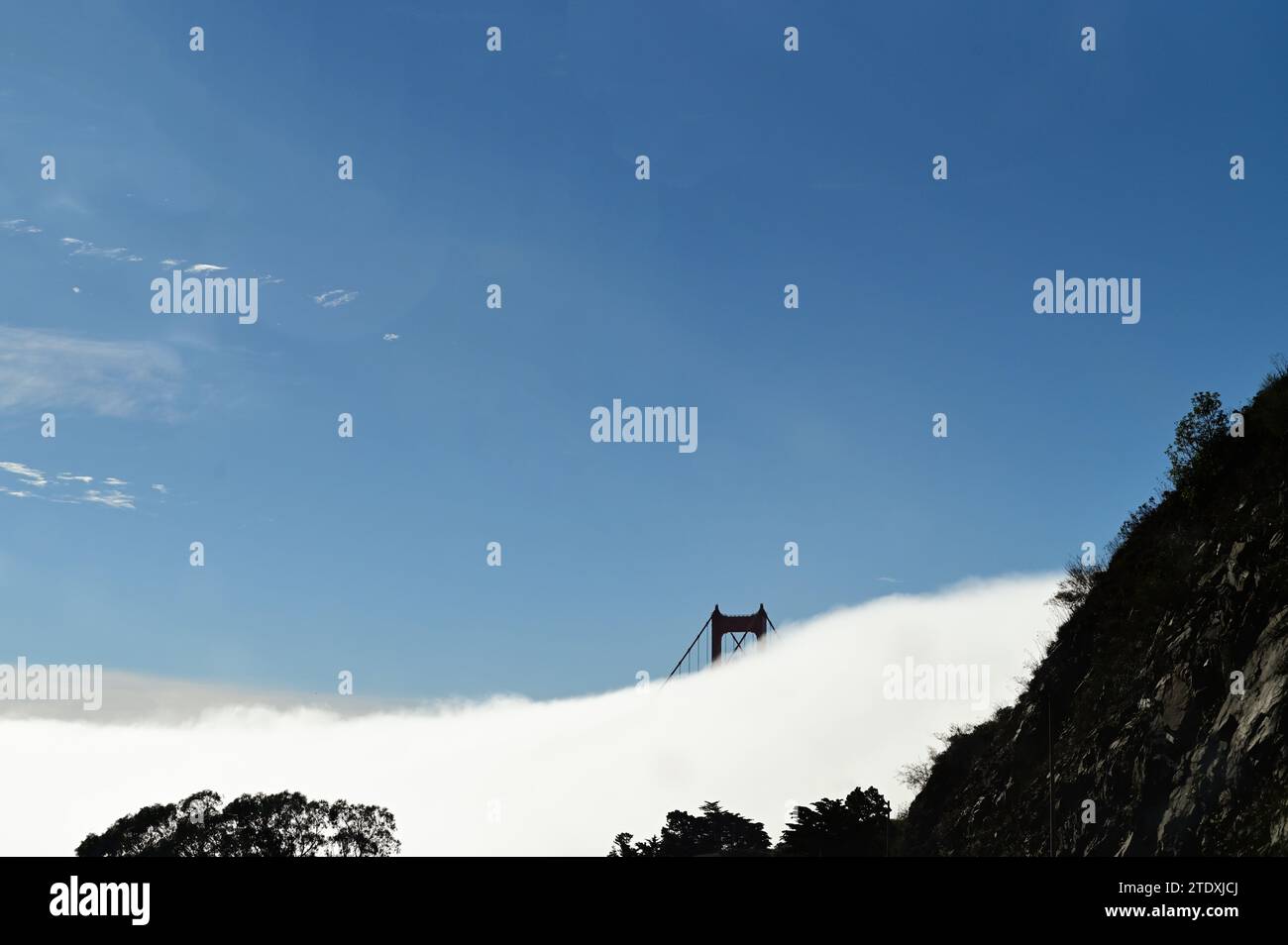 San Francisco, California, USA. Solo la parte superiore di una delle torri del Golden Gate Bridge è visibile come la nebbia ricopre il resto della struttura. Foto Stock