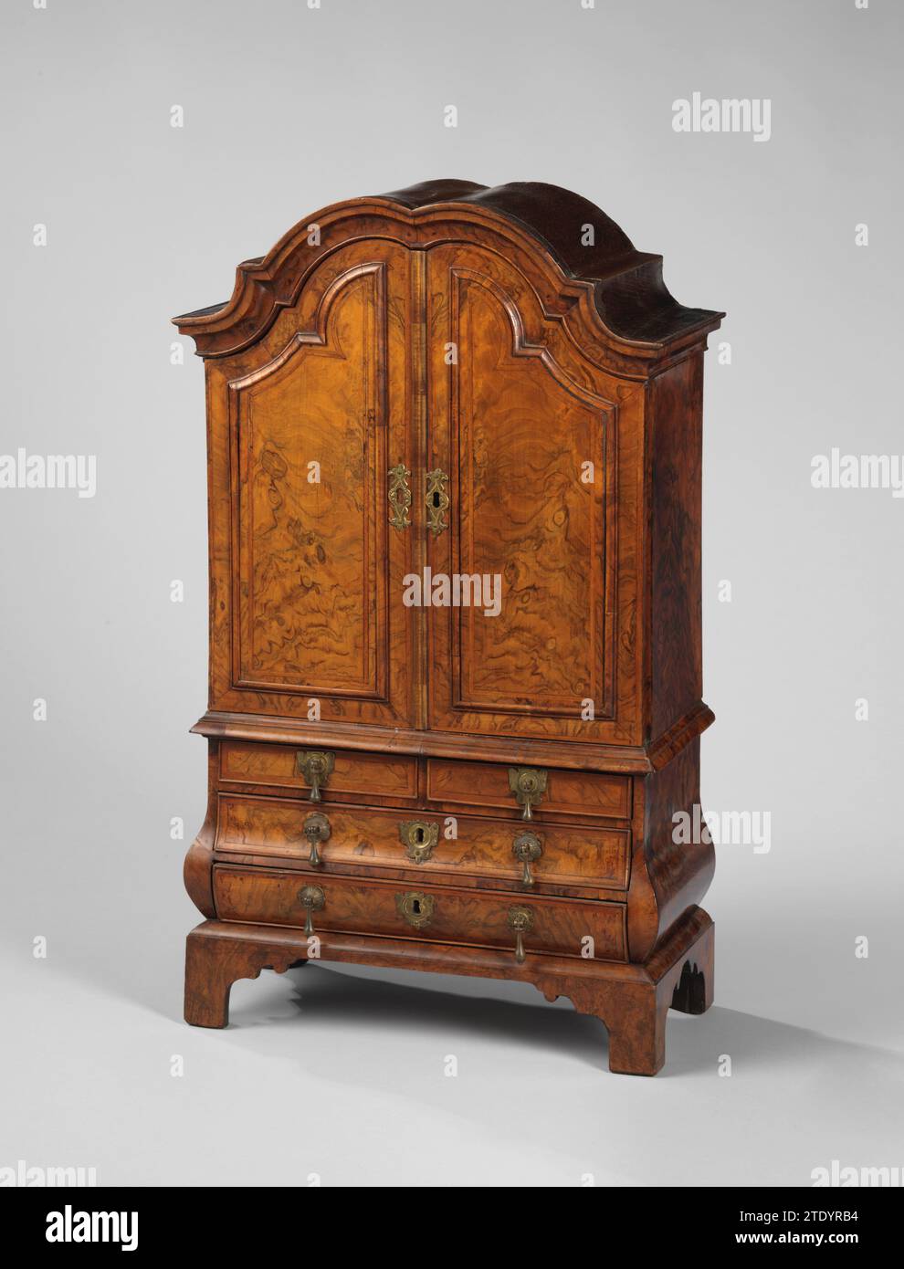 Mobili, Anonimo, 1700 - 1800 armadio in miniatura di rovere - legno incollato con dadi di radice. La parte inferiore è stata utilizzata e dispone di due cassetti grandi e due piccoli. La parte superiore presenta due ante con telai profilati che seguono il corso del cofano con cornice smerlata e profilata. Impasto di rame sugli sportelli; sui treker Laden Copper e sui due grandi cassetti una piastra di blocco in rame. I mobili poggiano su un piede sfregiato. Legno dei Paesi Bassi settentrionali (materiale vegetale). quercia (legno). Armadio in rame (metallo) in miniatura di rovere - legno incollato con dadi a radice. La parte inferiore è stata utilizzata e ha una tensione di Foto Stock