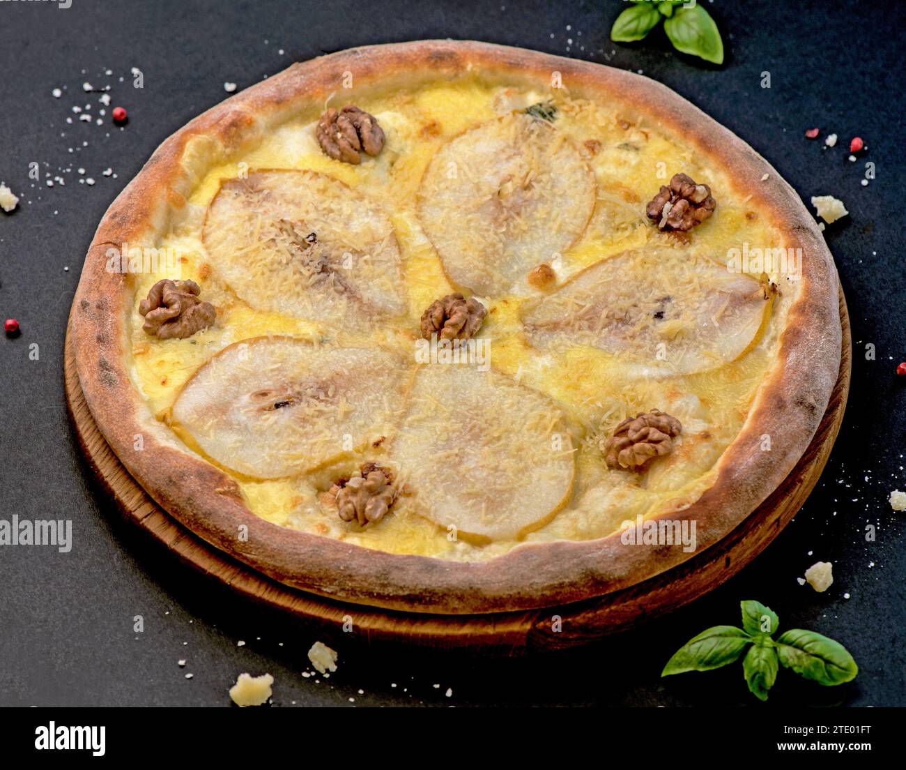 pizza con noci e pera su sfondo nero. Deliziosa pizza con pere, gorgonzola, noci Foto Stock