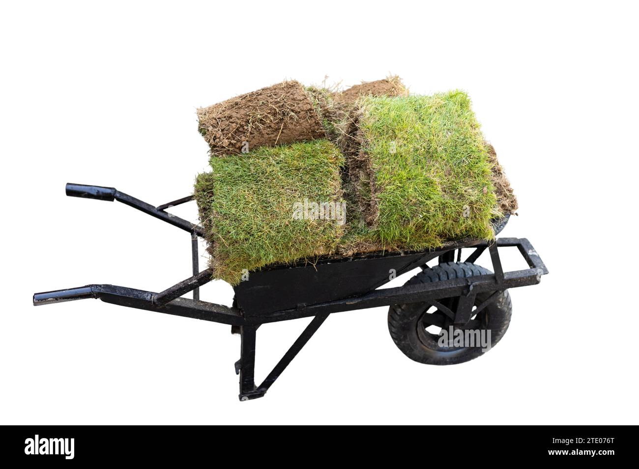 Vecchia carriola con pezzi di erba fresca isolati su sfondo bianco Foto Stock