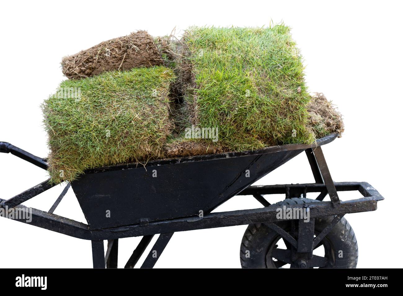 Carriola a mano che trasporta pezzi d'erba isolati su sfondo bianco Foto Stock
