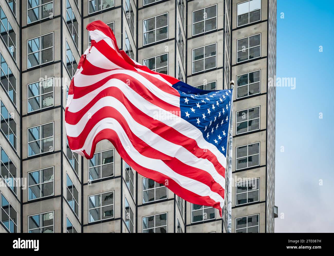 Bandiera americana davanti al grattacielo. Foto Stock