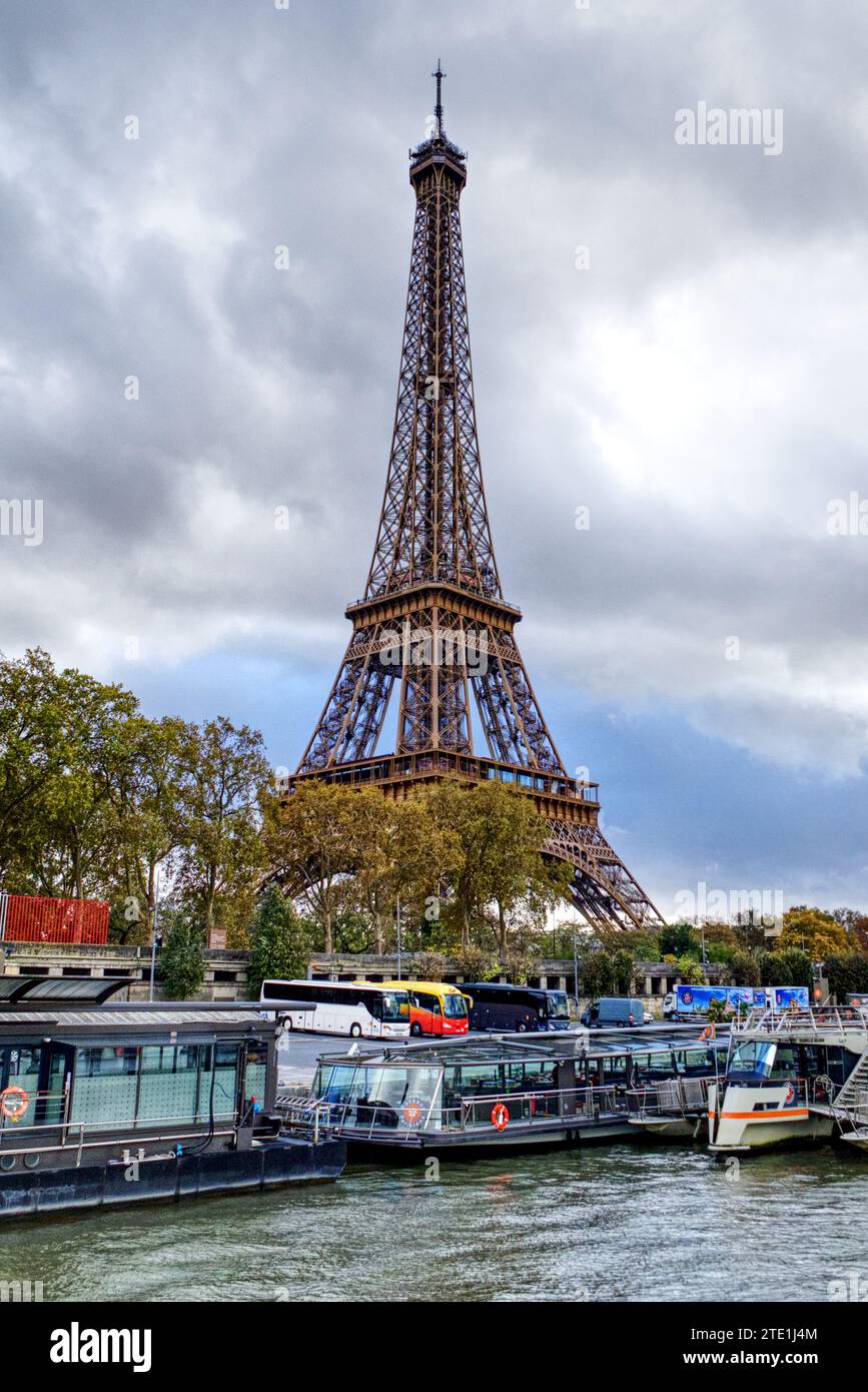 Parigi, Francia - autobus e barche da crociera ormeggiate sulla Senna, sovrastate dalla famosa Torre Eiffel Foto Stock
