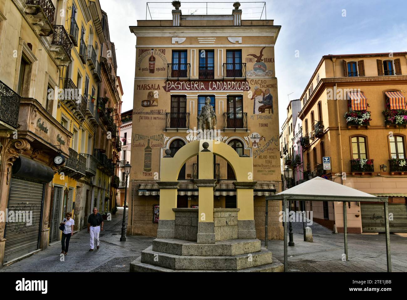 Fontana Maimoni e Pasticceria Lamarmora, una panetteria con una facciata splendidamente dipinta durante la siesta in Piazza Lamarmora, Iglesias, Sardegna, Italia Foto Stock