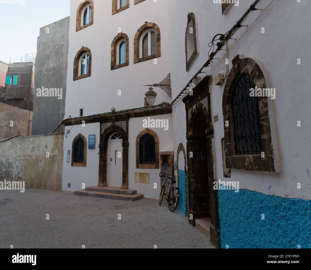 Elegante albergo blu e bianco con bicicletta nella medina nella città di Essaouira, Marocco. 19 dicembre 2023 Foto Stock
