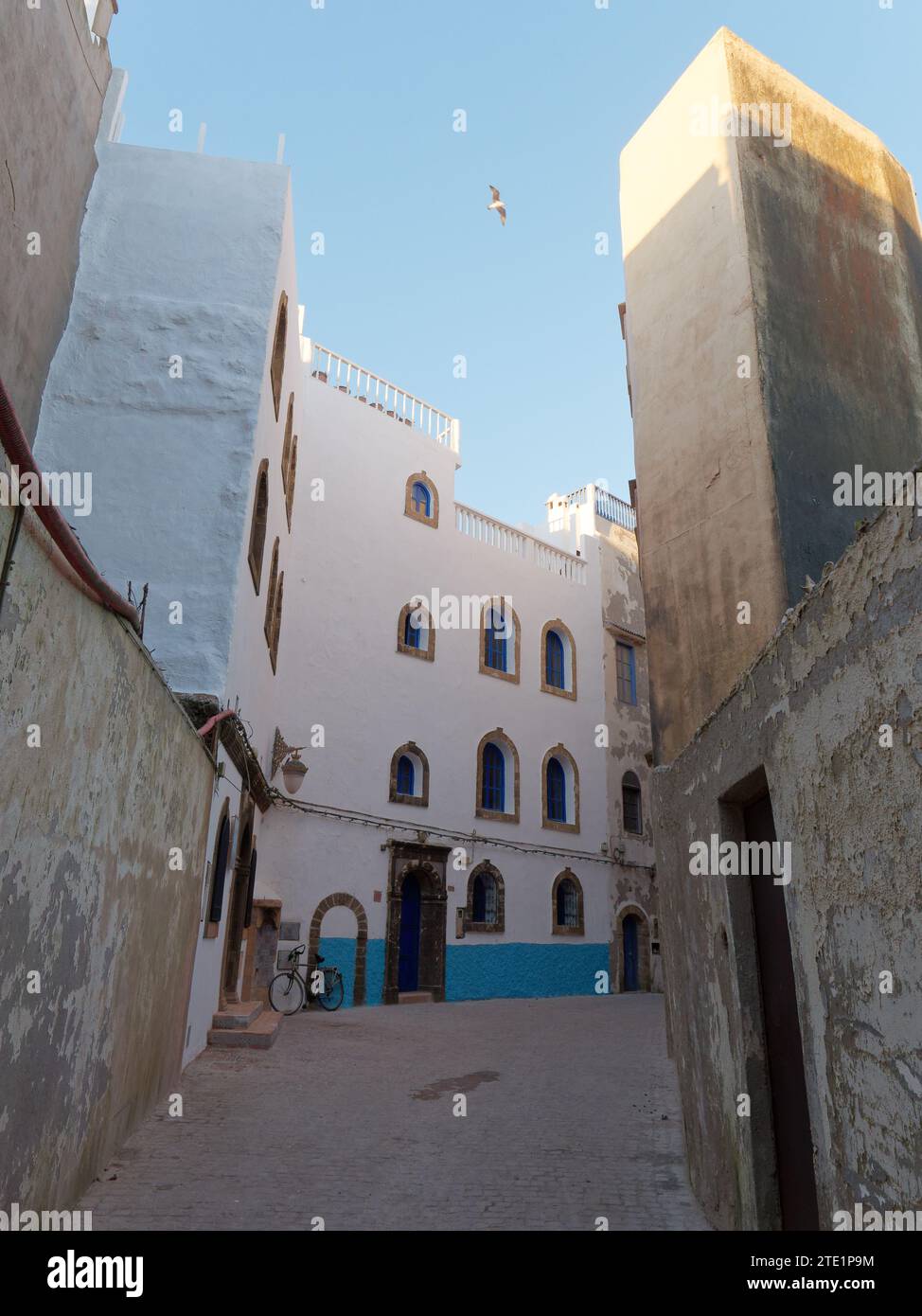 Elegante albergo blu e bianco con bicicletta nella medina nella città di Essaouira, Marocco. 19 dicembre 2023 Foto Stock