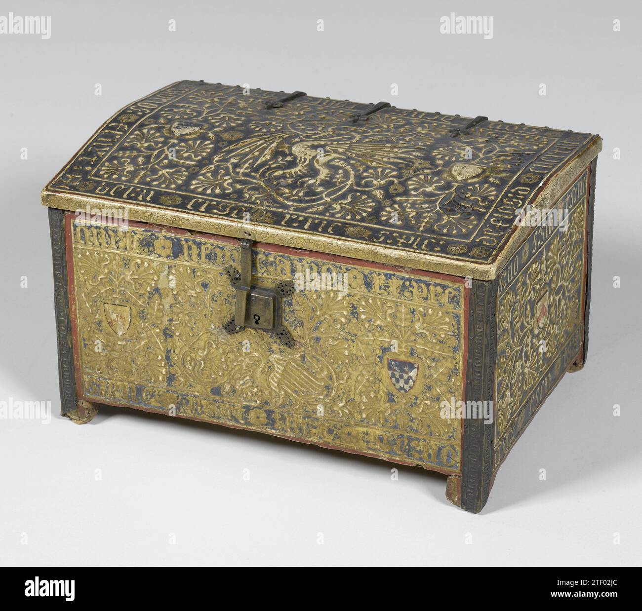 Torace in legno policromato e decorato con stucchi dorati sotto forma di stemmi con iscrizioni in latino, Anonimo, c. 1400 - c. 1500 piccolo torace di pioppo policromo, con decorazioni in stucco dorato costituito da viti a foglia con un drago fiancheggiato sul davanti e sul coperchio da stemmi con iscrizioni in latino. Nella parte posteriore quattro campi in piedi con viti a foglia, con iscrizioni. Anche la pastella sugli angoli formata da sottili lastre di rame mostra delle iscrizioni. La serratura e le maniglie sono in rame. La tappezzeria verde all'interno è parzialmente usurata. Legno italiano (pla Foto Stock