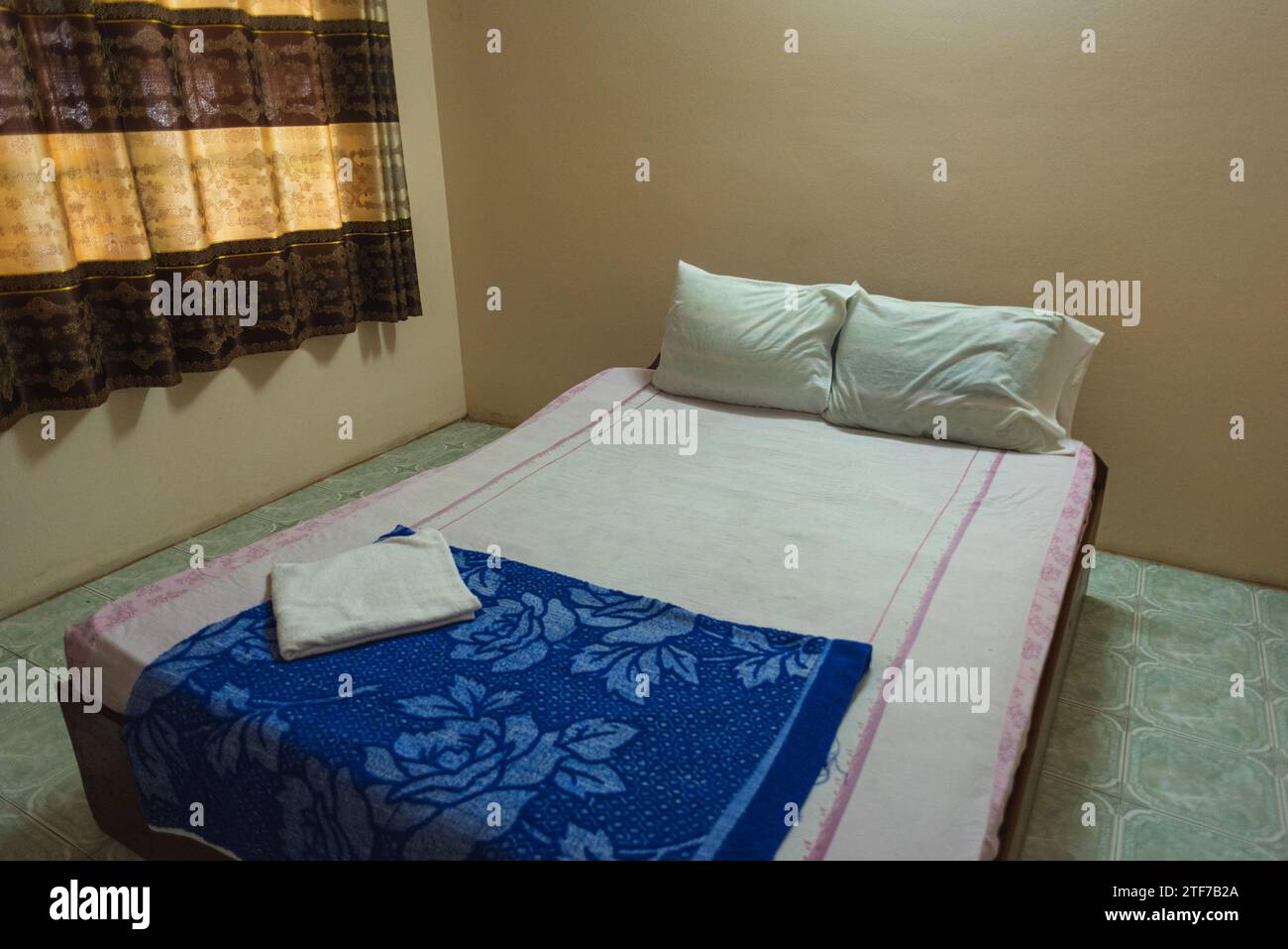 Letto matrimoniale in una piccola camera sporca dell'hotel in Laos Foto Stock
