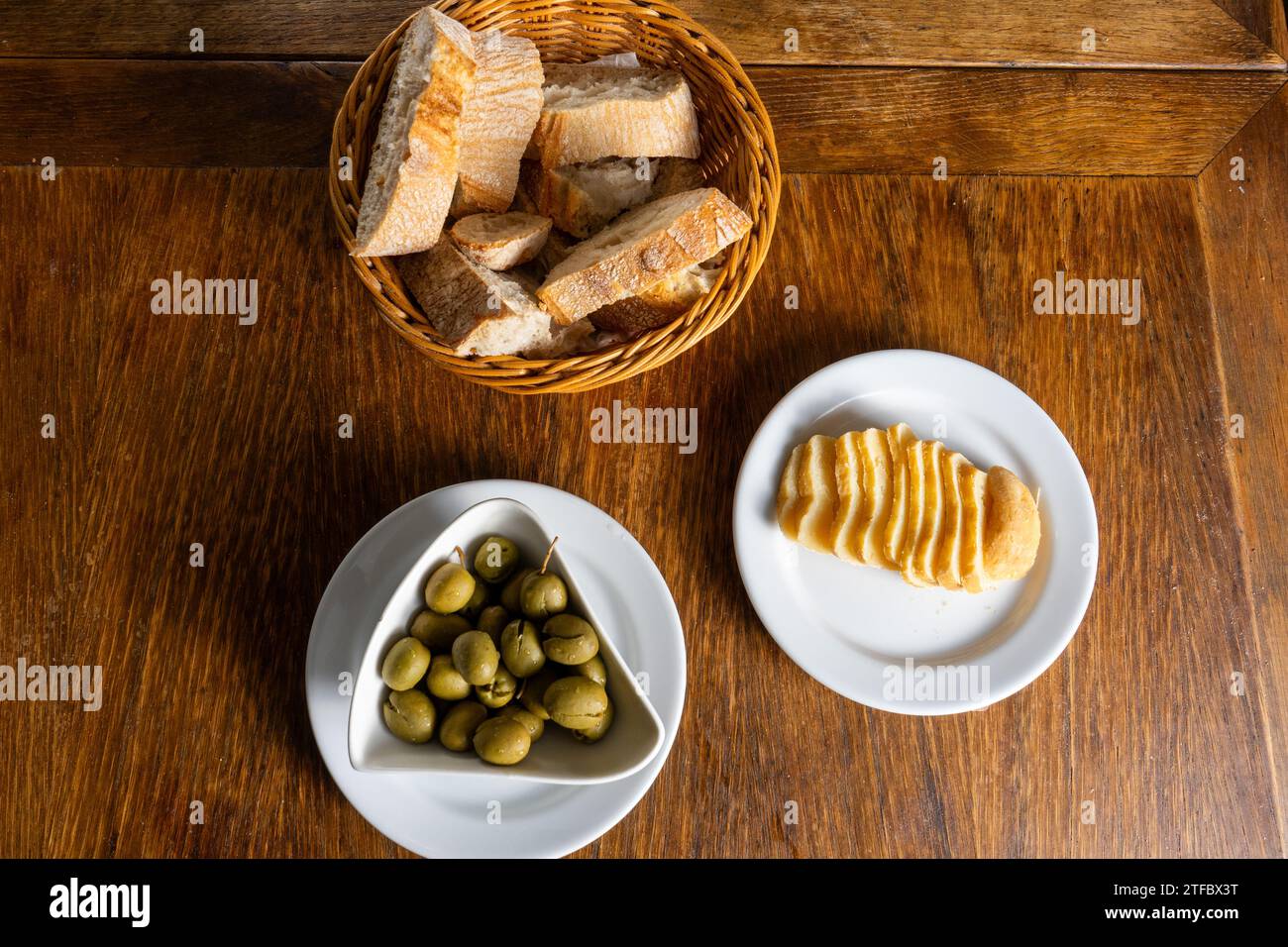 Tavolo rustico del ristorante Alentejo con olive verdi, formaggio Alentejo e pane tradizionale. Foto Stock