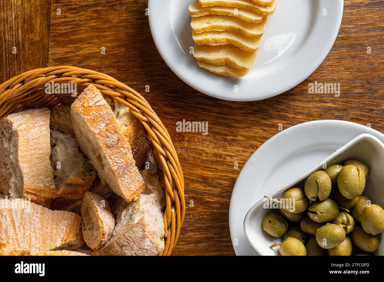 Tavolo rustico del ristorante Alentejo con olive verdi, formaggio Alentejo e pane tradizionale. Foto Stock