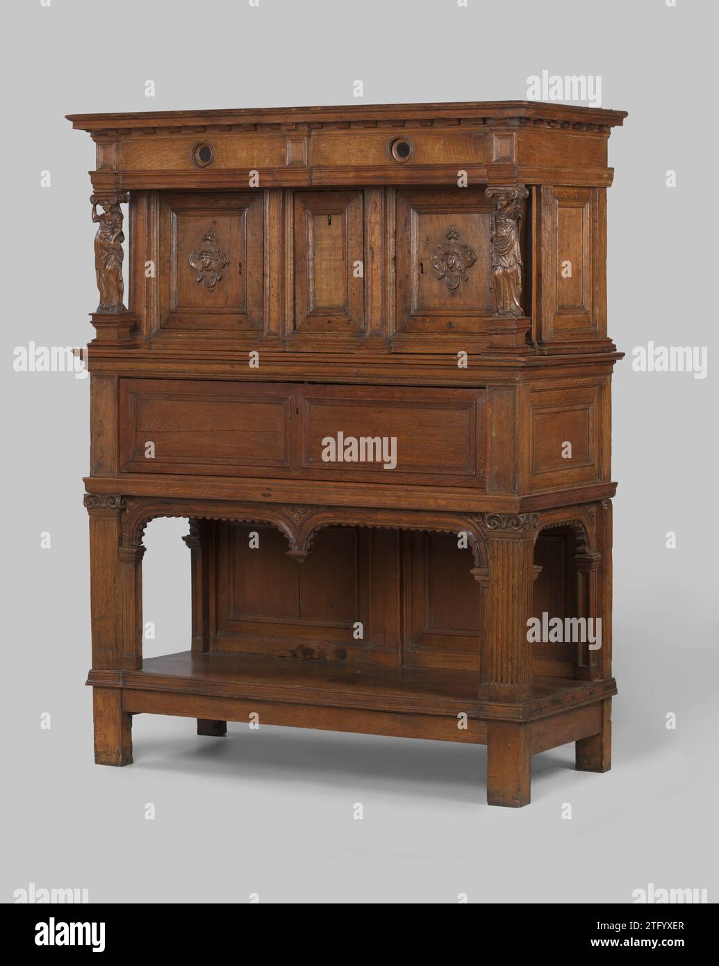 Armadio a buffet in rovere. Cappuccio indossato da Caratids, Anonymous, armadietto a buffet 1585 in rovere. I mobili sono divisi in un mobile inferiore e superiore. L'armadio di base è aperto e ha pilastri con capitelli ionici corrotti. L'apertura è eccessivamente tesa da due archi a cestello. L'armadietto superiore è dotato di due ante girevoli con un tappeto rotante e una maschera. Tra una porta a battente. Il cappuccio sporgente è indossato da due carativi: Uno con un libro, l'altro con una croce. Simboleggiano la fede. L'approfondimento rotondo sul frisone ha piastre inferiori in ebano. Legno olandese (materiale vegetale). quercia (legno). ebo Foto Stock