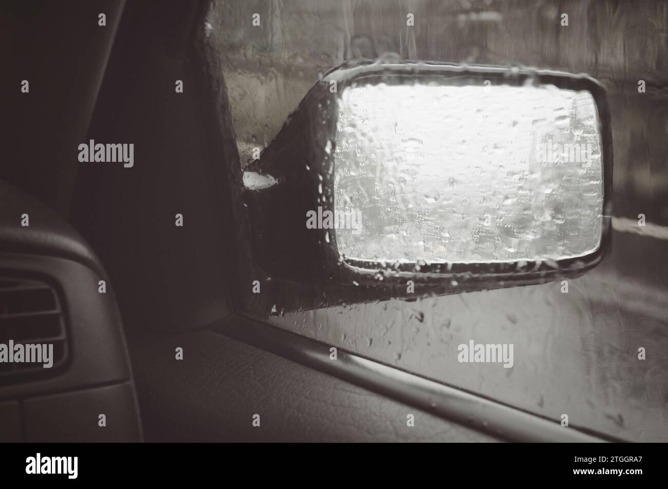 la pioggia cade sullo specchietto retrovisore Foto Stock
