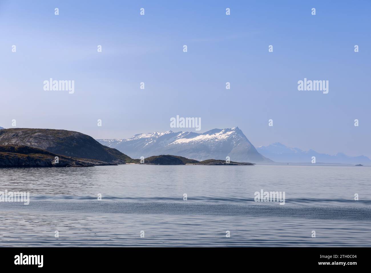Una pittoresca scena estiva da un traghetto in viaggio verso l'isola di Lofoten, in Norvegia, che mostra il Mare del Nord con acque tranquille e aspre montagne Foto Stock