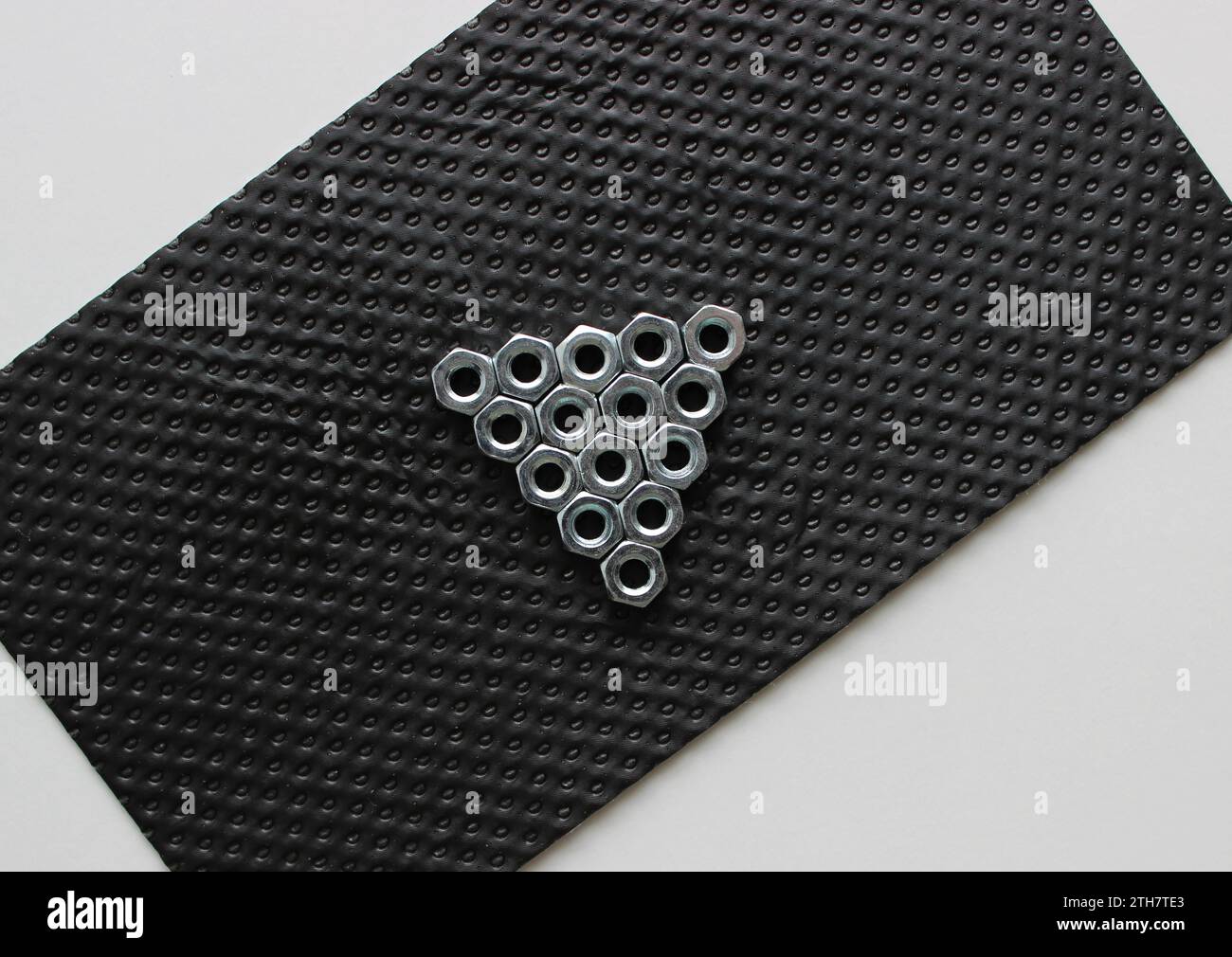 Icona di riproduzione multimediale realizzata con dadi in acciaio su pannello in plastica perforata Foto Stock