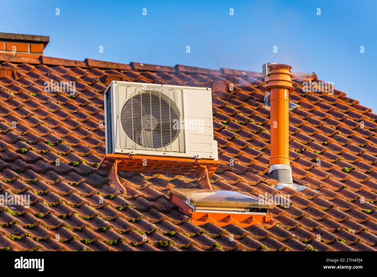 Compressore a doppio invertitore, combinazione di compressore del climatizzatore e pompa di riscaldamento, installato sul tetto di una casa di famiglia. Foto Stock