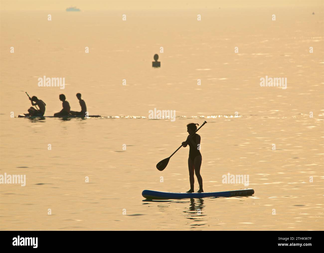 Sagome di persone su paddleboard - Brighton, East Sussex, Inghilterra. Calde giornate estive. Foto Stock