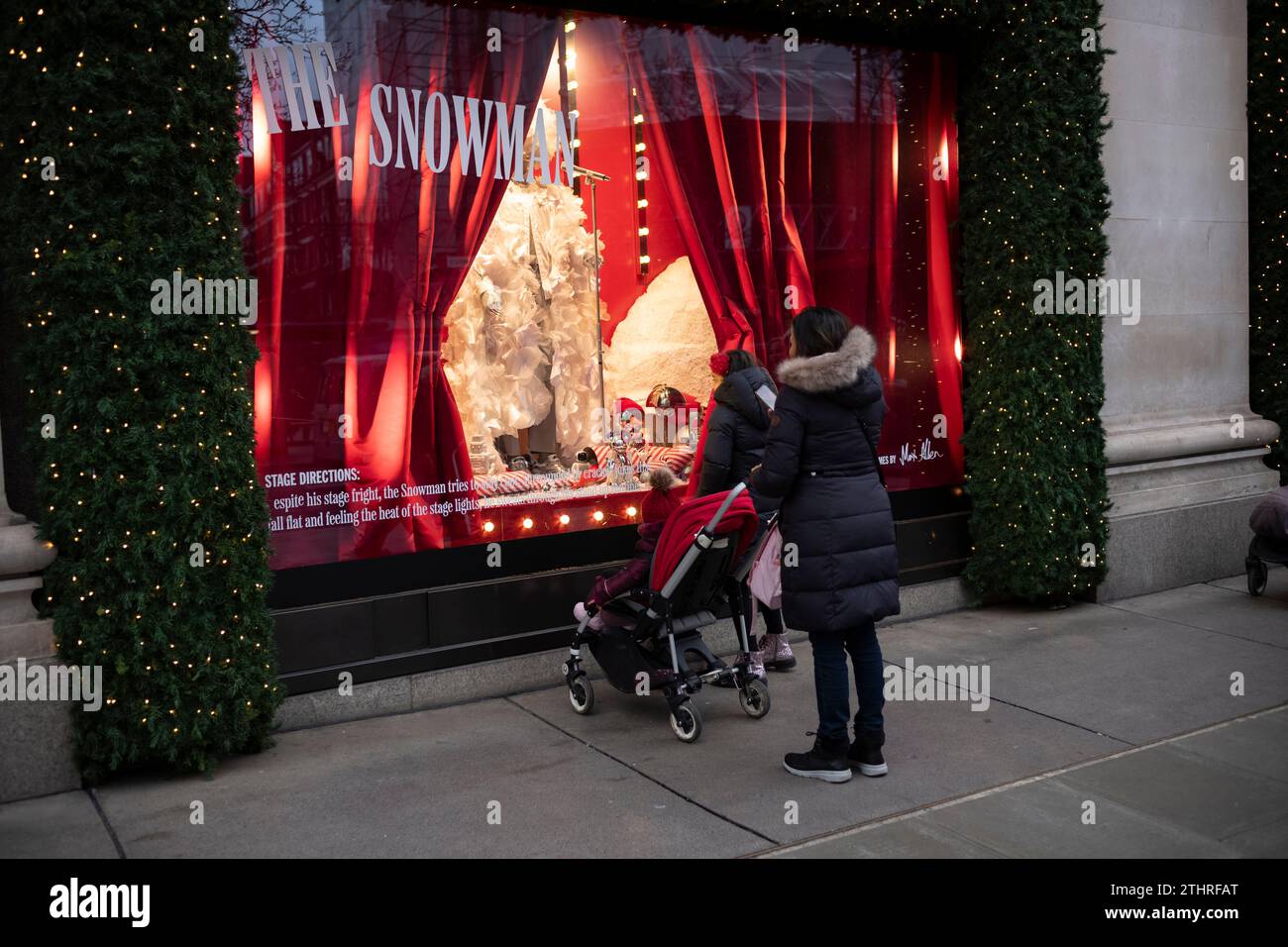 I turisti festivi che guardano le vetrine di Natale fuori dai grandi magazzini Selfridges nel West End di Londra, 20 dicembre 2023. Foto Stock