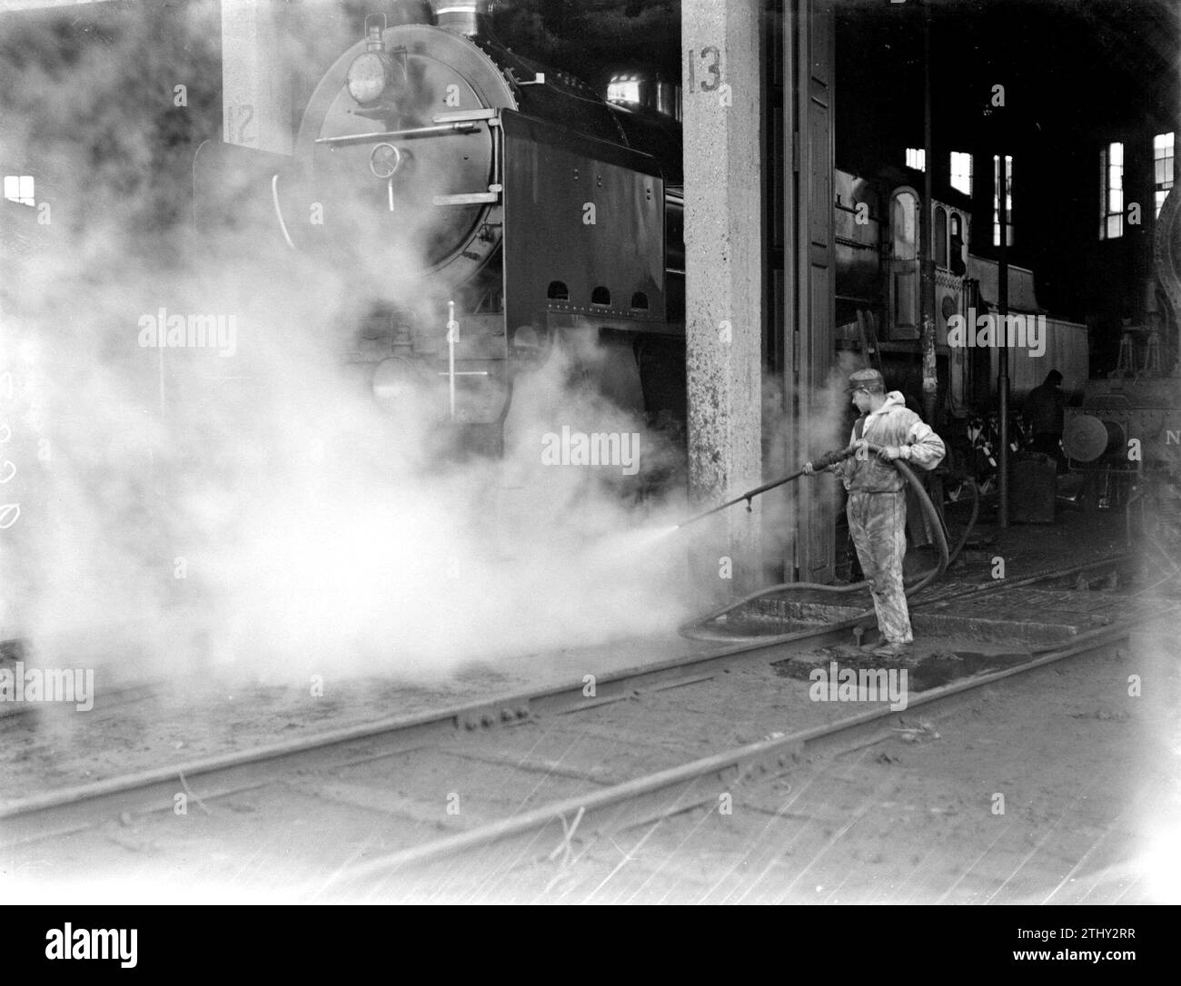 Man spruzza una locomotiva a vapore pulita CA. 1932 Foto Stock