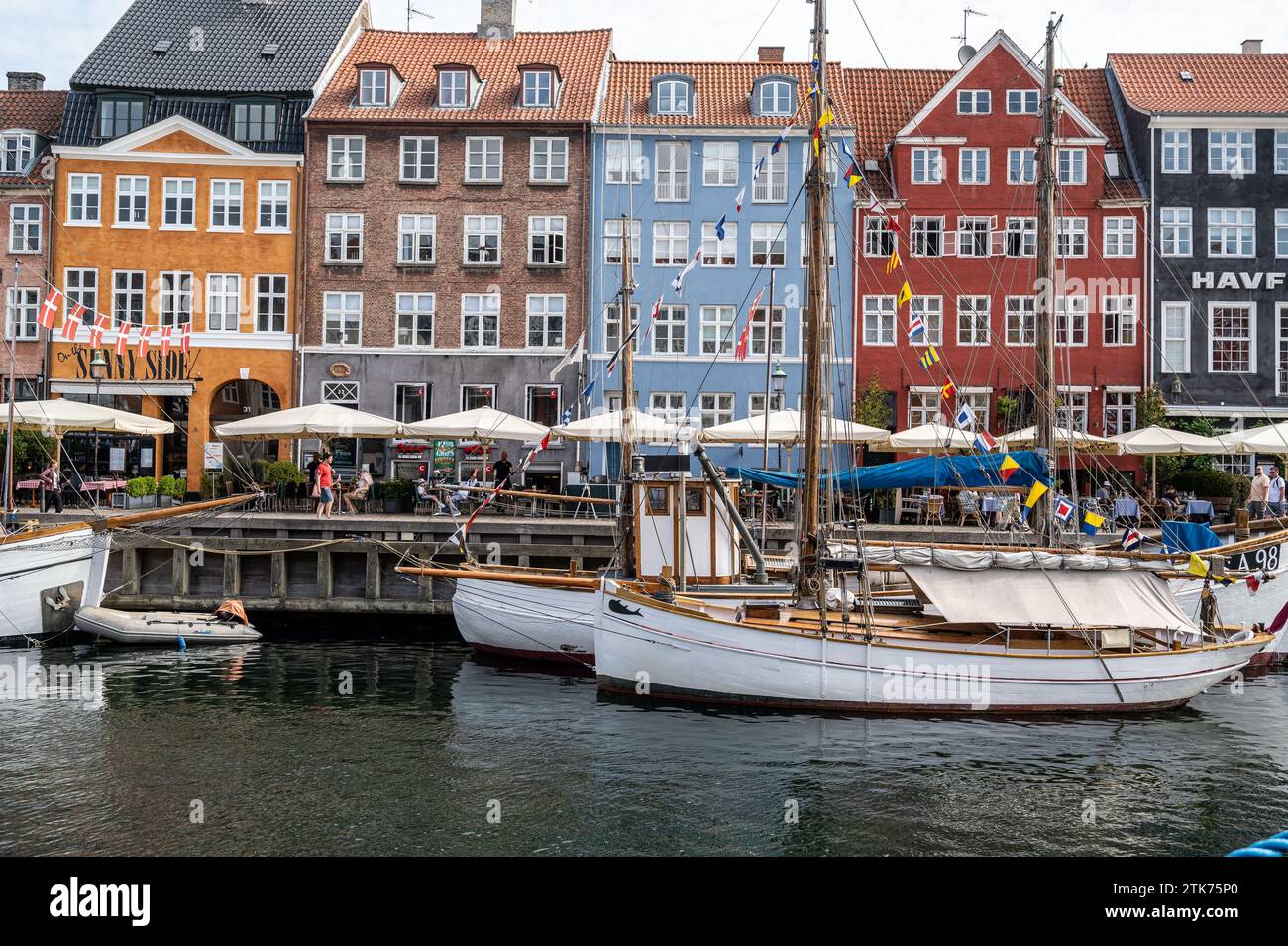 Facciata colorata e vecchie navi lungo il canale Nyhavn a Copenaghen, Danimarca Foto Stock
