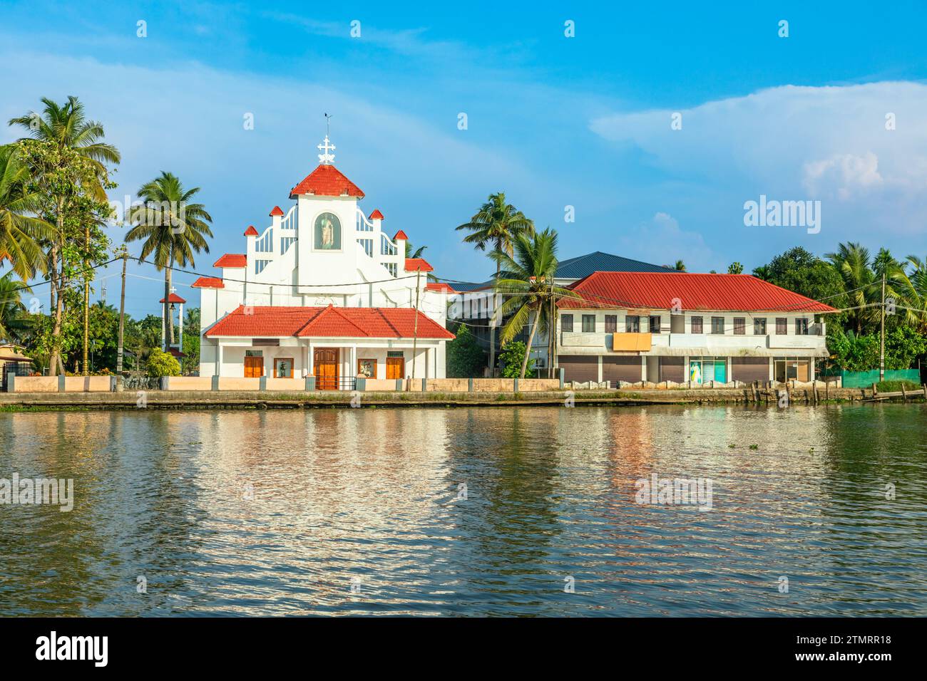 Antica chiesa cattolica coloniale di San Tommaso sulla costa del fiume Pamba, con palme, Alleppey, Kerala, India meridionale Foto Stock