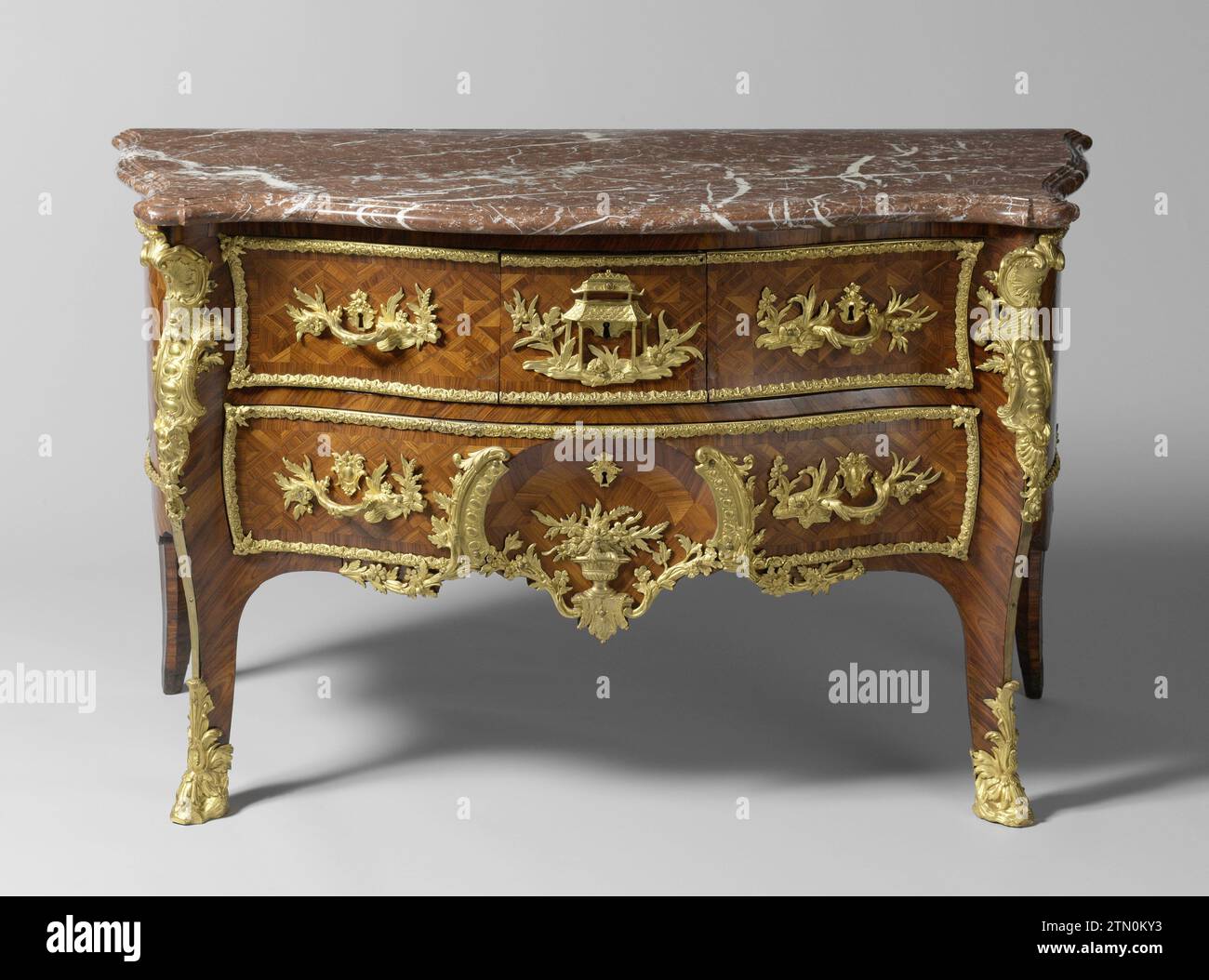 Commode, anonimo, c. 1730 - c. 1745 Commode decorato con marqueterie in Violethout su nucleo di legno di pino. I mobili sono A Forma Di S, con coperture posizionate sulle gambe anteriori con pastella e pneumatici in rame. La parte anteriore usata ha tre cassetti nel campo superiore, la pastella centrale con un tempio cinese. Il cassetto nel campo inferiore ha una nicchia al centro, continuamente fino alla soglia. Entrambi i campi sono stati decorati prevalentemente con rami di fiori e foglie e volute di foglie in bronzo dorato. L'involucro è realizzato in marmo rosso-marrone venato. Legno di Parigi (materiale vegetale). abete rosso (legno). quercia (legno). kingwood (wo Foto Stock